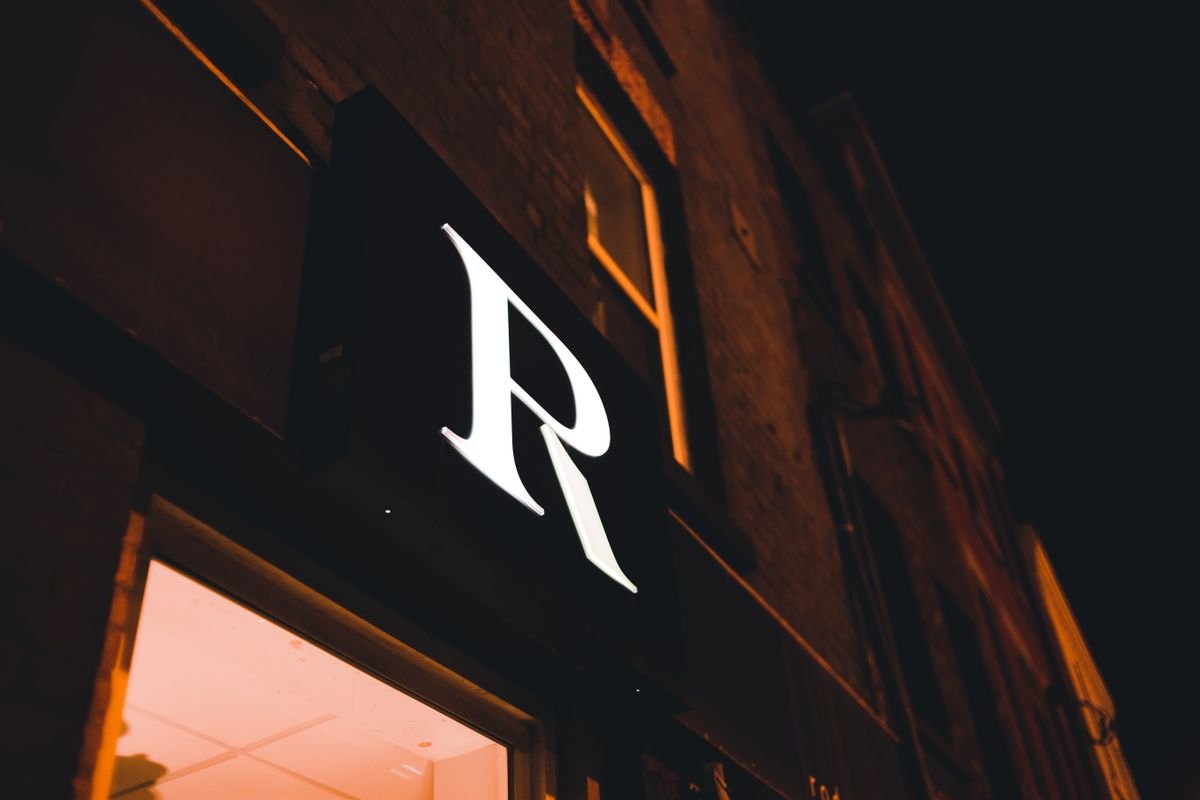 Stock reference of an illuminated shop sign at night