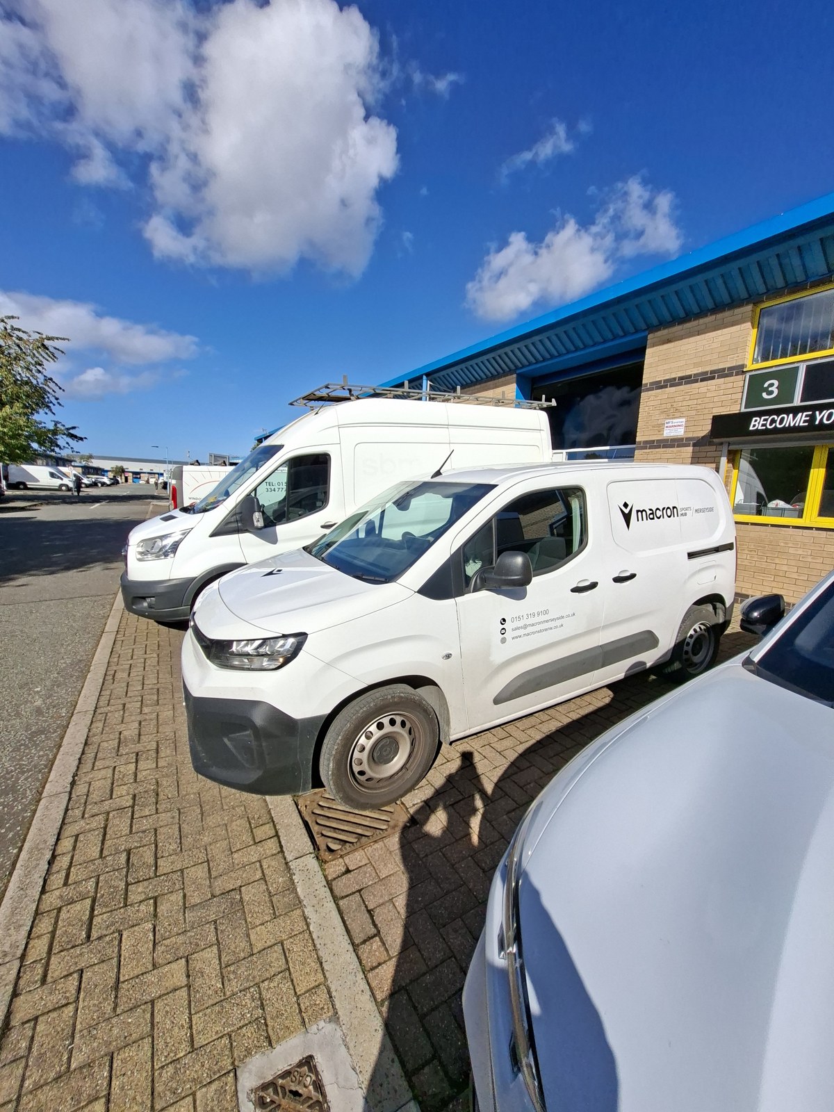 Macron van graphics. Logo and contact lettering on a white commercial van.